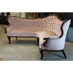 an old fashioned couch and footstool in a warehouse