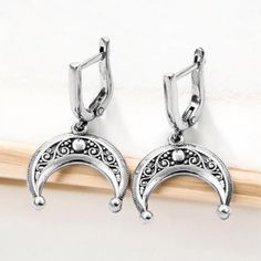 Embrace the mystique of the moon with these stunning half moon earrings. Handcrafted from high-quality sterling silver, these lunula earrings feature an intricate design inspired by Viking jewelry and celestial themes. Perfect for those who love boho style and lunar symbolism, these earrings capture the beauty and mystery of a lunar eclipse. These sterling silver lunula earrings are both elegant and durable, making them ideal for everyday wear or special occasions. The detailed craftsmanship ref Elegant Crescent Earrings For Gift, Elegant Crescent Metal Jewelry, Elegant Crescent Shaped Metal Jewelry, Elegant Crescent-shaped Metal Jewelry, Elegant Moon Phase Earrings, Elegant Semi-circle Metal Earrings, Celestial Style Silver Jewelry, Silver Symbolic Crescent Earrings, Symbolic Silver Crescent Earrings