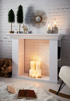 a white fireplace with candles and christmas decorations