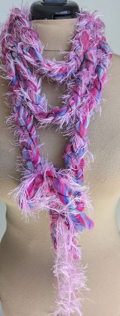 This very frilly whimsical braided pink and purple yarn scarf can be worn a few different ways. Pink Bohemian Scarf One Size, Pink Crochet Bohemian Scarves, Pink Crochet Bohemian Scarf, Bohemian Pink Crochet Scarves, Pink Bohemian Crochet Scarves, Bohemian Pink Crochet Scarf, Purple Crochet Yarn Scarves, Purple Crochet Scarves One Size, Purple Crochet Scarf One Size