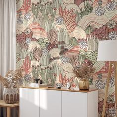 a wallpapered room with an assortment of plants and flowers on the sideboard