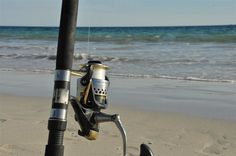 a fishing rod and reel on the beach