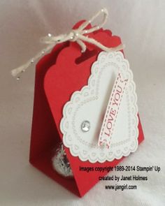 a small red gift bag with a tag attached to it