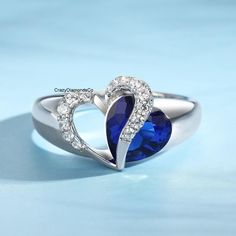 two heart shaped blue sapphire and diamond ring on a light blue background with copy space