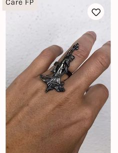 a woman's hand wearing a ring with an image of a bird on it