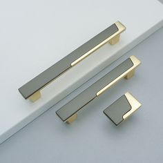 three different types of door handles on a white surface with grey and gold trimmings