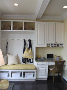 a home office with white cabinets and drawers