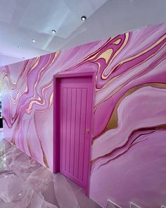 a pink and gold painted wall with an open door