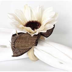 a white and brown flower on top of a napkin