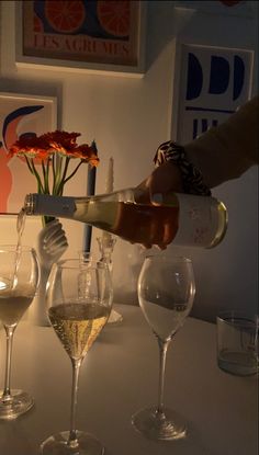 a person pouring wine into glasses on a table