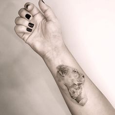 a woman's arm with a small dog tattoo on the left side of her wrist