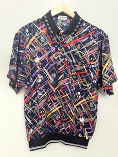 "American made menswear great casual Friday shirt for hime, perfect for valentine day gift birthday or fatherly gift.  Sytlish modern this will great on that special man in your life.Will look great on him in either linen pants or jeans. this chic and timeless pattern is for that man who enjoys turning heads. Made in the 🇺🇸 USA by Statel Horse  This shirt is large medium and it is in pristine condition. Size chest 44\"	in stock	64.85 USD	"	0.00 USD	Clothing > Men's Clothing > Shirts & Tees > D Purple Collared Top With Graphic Print, Casual Purple Collared Top, Retro Graphic Print Polo Collar Tops, Spring Graphic Print Polo Shirt, Spring Graphic Print Short Sleeve Polo Shirt, Retro Collared Polo Shirt With Graphic Print, Summer Graphic Print Collared Polo Shirt, Multicolor Polo Collar Top With Graphic Print, Multicolor Graphic Print Polo Collar Top