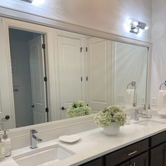 a bathroom with double sinks and large mirrors