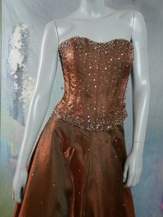 This stunning golden bronze satin formal dress sparkles with silver sequins and diamanté jewel beading throughout its design. The bodice front is a constellation of sequins and jeweled beading, and the back of the bodice features a corset-style lacing that enables you to fit the top to best complement your form. Bust = 34 inches (86cm) Top Waist = 28 inches (71cm) Top Length (bust line to hemline) = 14 inches (35.5cm) Top Back Zipper = 9.5 inches (24cm) Skirt Waist = 27.5 inches (70cm) Skirt Hip Sequin Fitted Evening Dress For Debutante Ball, Glamorous Satin Evening Dress For Debutante Ball, Elegant Satin Gown With Sequins, Sparkling Fitted Evening Dress For Debutante Ball, Satin Gown With Sequins And Fitted Bodice, Glamorous Satin Gown With Sequins, Glamorous Satin Sequin Gown, Embellished Satin Gown For Gala, Gala Evening Dress With Sequins And Satin