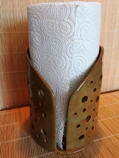 a close up of a toilet paper holder on a wooden floor with tiles in the background