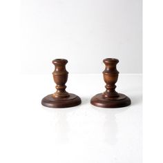 two wooden candlesticks sitting on top of a white table