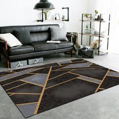 a living room with a black leather couch and brown rug on the floor in front of it