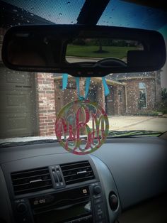 the inside of a car with two monogrammed circles hanging from it's dash board