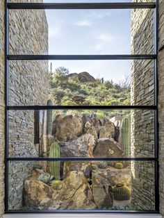 an open window with rocks and cacti in it