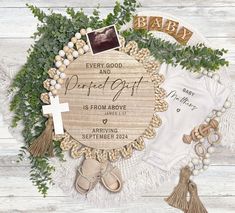 a baby announcement surrounded by greenery and other items