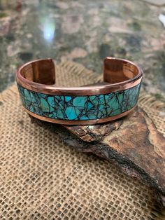 *  King Man Turquoise Inlay. Black Matrix light blue. *  Milled Solid Copper. * 0.75" Wide. 3 mm Thickness. 0.5" Wide is available on the option. *  Polished and Waxed. *  Blue  and Black Matrix Turquoise.  Mark your color on the option. * Made to order. Measure your whole wrist tightly on the wrist bone and mark it on the option. Adjustable Turquoise Bracelet With Patina, Adjustable Turquoise Bracelets With Patina, Artisan Round Turquoise Cuff Bracelet, Artisan Turquoise Round Bracelet, Artisan Blue Cuff Bangle Bracelet, Artisan Blue Bangle Cuff Bracelet, Artisan Turquoise Bracelet With Inlay, Artisan Turquoise Bracelets With Inlay, Turquoise Patina Cuff Bracelet As A Gift