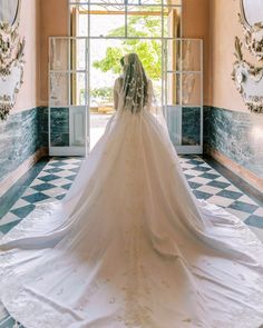 a woman in a wedding dress is standing at the entrance to a room with blue and white walls