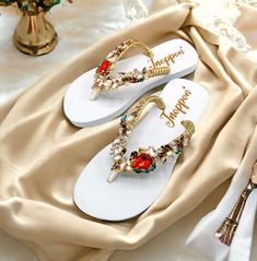 Description The beautiful rhinestone and customizable Flip Flops for the beach brides, bridesmaids, vacation, honeymoon or any occasion you desire to look gorgeous. Perfect in any outfit! Being unique and stunning on design, these flip flops must be your must-have item! The sandal is anti-slip, comfortable and durable as it is made from high quality rubber from the South of Thailand, where is famous for the best rubber tree. Moreover, the crystals are decorated on the sandal with effective adhesive glue and knitting threads by hand stitching. Don't worry when you walk on the beach or use it in the rainy season. For anyone who loves a real handmade product, don't miss it out! Product Description: - Thailand High-Quality Rubber Sole - Luxury Crystals/Rhinestones  - High-quality PU gold threa Summer Wedding Shoes With Rhinestones And Round Toe, Summer Wedding Shoes With Rhinestones, Embellished Sandals For Beach Party, Gold Sandals For Summer Beach Wedding, Embellished Sandals For Beach Season Parties, Gold Rhinestone Flip Flops For Vacation, Elegant Embellished Flip Flops For Vacation, White Flip Flops For Beach Season Parties, Elegant Gold Flip Flops For The Beach