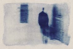 a blurry image of a man standing in front of a door with his back to the camera