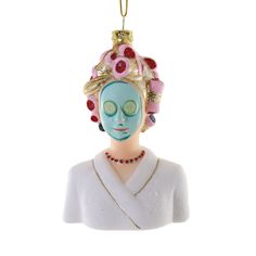 a ceramic ornament with a woman's face painted blue and pink on it