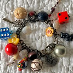 a close up of a bracelet on a bed with beads and charms attached to it