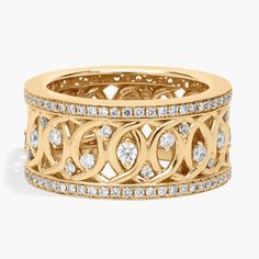 a yellow gold ring with diamonds on the sides and an intricate design in the middle