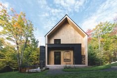 the house is made out of wood and has black shingles on the front door