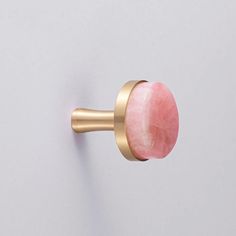 a close up of a door knob with a pink stone on the front and gold trim