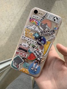 someone is holding up their phone case with stickers on it