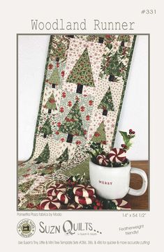 a coffee cup sitting on top of a table next to a christmas tree quilt pattern