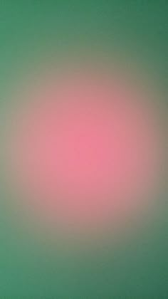 a blurry image of a pink and green background with the light reflecting on it's surface