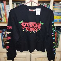 New With Tags Stranger Things Cropped Sweater. Super Soft And Cozy, Perfect Holiday Sweater! Please Ask Any Questions Prior To Purchase, I'm Happy To Send More Photos. Photos Are Part Of The Description. Measurements Are Approximate To The Best Of My Ability. Comes From A Smoke Free, Pet Friendly Home. I Have Lots Of Other Cute Goodies And Several Other Listings And I'm Always Happy To Bundle For Shipping Deals! Christmas Long Sleeve Sweater, Black Long Sleeve Christmas Sweatshirt, Cozy Black Tops With Graphic Print, Cozy Black Top With Graphic Print, Christmas Streetwear Long Sleeve Sweater, Christmas Long Sleeve Sweater For Streetwear, Christmas Long Sleeve Streetwear Sweater, Cozy Fit Long Sleeve Graphic Sweater, Black Long Sleeve Sweatshirt For Holiday