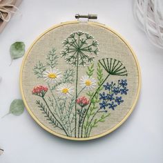 an embroidery project with flowers and leaves on it