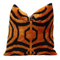 an orange and black pillow on a white background