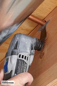 a person using a drill to fix a wood panel