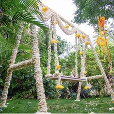 an outdoor wedding setup with flowers on the trees and white fabric hanging from it's sides