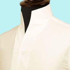 High Open Collar Full Sleeves Shirt Tailor-Made On Order shirt 𝘈 𝘩𝘪𝘨𝘩 𝘤𝘰𝘭𝘭𝘢𝘳 𝘴𝘩𝘪𝘳𝘵 𝘪𝘴 𝘢 𝘤𝘭𝘢𝘴𝘴𝘪𝘤 𝘢𝘯𝘥 𝘵𝘪𝘮𝘦𝘭𝘦𝘴𝘴 𝘴𝘵𝘺𝘭𝘦 𝘵𝘩𝘢𝘵 𝘢𝘥𝘥𝘴 𝘢 𝘵𝘰𝘶𝘤𝘩 𝘰𝘧 𝘴𝘰𝘱𝘩𝘪𝘴𝘵𝘪𝘤𝘢𝘵𝘪𝘰𝘯 𝘵𝘰 𝘢𝘯𝘺 𝘰𝘶𝘵𝘧𝘪𝘵. 𝘛𝘩𝘪𝘴 𝘴𝘵𝘺𝘭𝘦 𝘧𝘦𝘢𝘵𝘶𝘳𝘦𝘴 𝘢 𝘤𝘰𝘭𝘭𝘢𝘳 𝘵𝘩𝘢𝘵 𝘴𝘵𝘢𝘯𝘥𝘴 𝘶𝘱 𝘢𝘯𝘥 𝘦𝘯𝘤𝘪𝘳𝘤𝘭𝘦𝘴 𝘵𝘩𝘦 𝘯𝘦𝘤𝘬, 𝘱𝘳𝘰𝘷𝘪𝘥𝘪𝘯𝘨 𝘢 𝘳𝘦𝘧𝘪𝘯𝘦𝘥 𝘢𝘯𝘥 𝘱𝘰𝘭𝘪𝘴𝘩𝘦𝘥 𝘭𝘰𝘰𝘬. 𝘐𝘵'𝘴 𝘢 𝘷𝘦𝘳𝘴𝘢𝘵𝘪𝘭𝘦 𝘱𝘪𝘦𝘤𝘦 𝘰𝘧 𝘤𝘭𝘰𝘵𝘩𝘪𝘯𝘨 𝘵𝘩𝘢𝘵 𝘤𝘢𝘯 𝘣𝘦 𝘸𝘰𝘳𝘯 𝘸𝘪𝘵𝘩 𝘢 𝘴𝘶𝘪𝘵 𝘧𝘰𝘳 𝘧𝘰𝘳𝘮𝘢𝘭 𝘰𝘤𝘤𝘢𝘴𝘪𝘰𝘯𝘴 𝘰𝘳 𝘥𝘳𝘦𝘴𝘴𝘦𝘥 𝘥𝘰𝘸𝘯 𝘸𝘪𝘵𝘩 𝘫𝘦𝘢𝘯𝘴 𝘧𝘰𝘳 𝘢 𝘤𝘢𝘴𝘶𝘢𝘭 𝘭𝘰𝘰𝘬. 𝘛𝘩𝘦 𝘩𝘪𝘨𝘩 𝘤𝘰𝘭𝘭𝘢𝘳 𝘢𝘭𝘴𝘰 𝘰𝘧𝘧𝘦𝘳𝘴 𝘢𝘥𝘥𝘪𝘵𝘪𝘰𝘯𝘢𝘭 𝘤𝘰𝘷𝘦𝘳𝘢𝘨𝘦 𝘢𝘯𝘥 𝘱𝘳𝘰𝘵𝘦𝘤𝘵𝘪𝘰𝘯 𝘢𝘨? Formal Tops With Covered Buttons And Collar, White Formal Tops With Covered Buttons, Formal White Tops With Covered Buttons, Classic White Tops With Covered Buttons, White Stand Collar Shirt With Button Closure, Classic Formal Tops With Covered Buttons, Classic Blouse With Collar And Concealed Placket, Classic White Blouse With Hidden Button Closure, Classic Tops With Fold Down Collar For Daywear