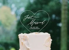 a wedding cake with the name just married written on it and a heart - shaped topper