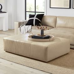 a living room filled with furniture and a coffee table in front of a large window