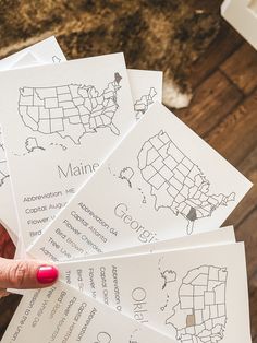 a person holding five maps in their hands with the names of each country on them