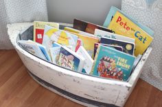 a basket filled with books sitting on top of a wooden floor