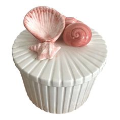 two pink seashells sitting on top of a white container