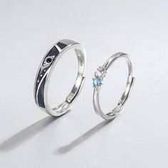 two silver rings with blue and white stones on each one, sitting side by side