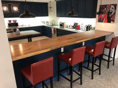 a kitchen with an island and bar stools next to it in front of the counter