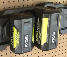 two batteries sitting on top of a shelf next to each other